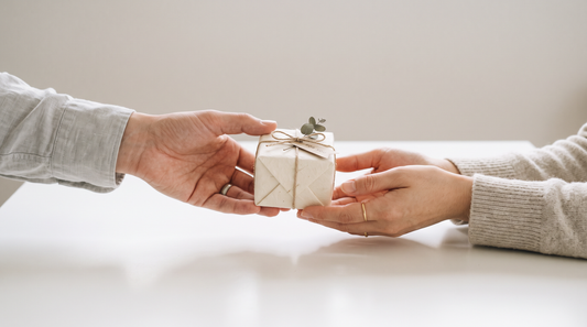 Two hands exchanging a small gift, representing the reciprocity principle