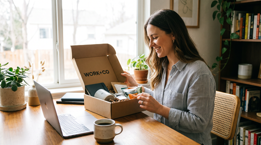 Remote worker opening a branded gift box at their home office desk