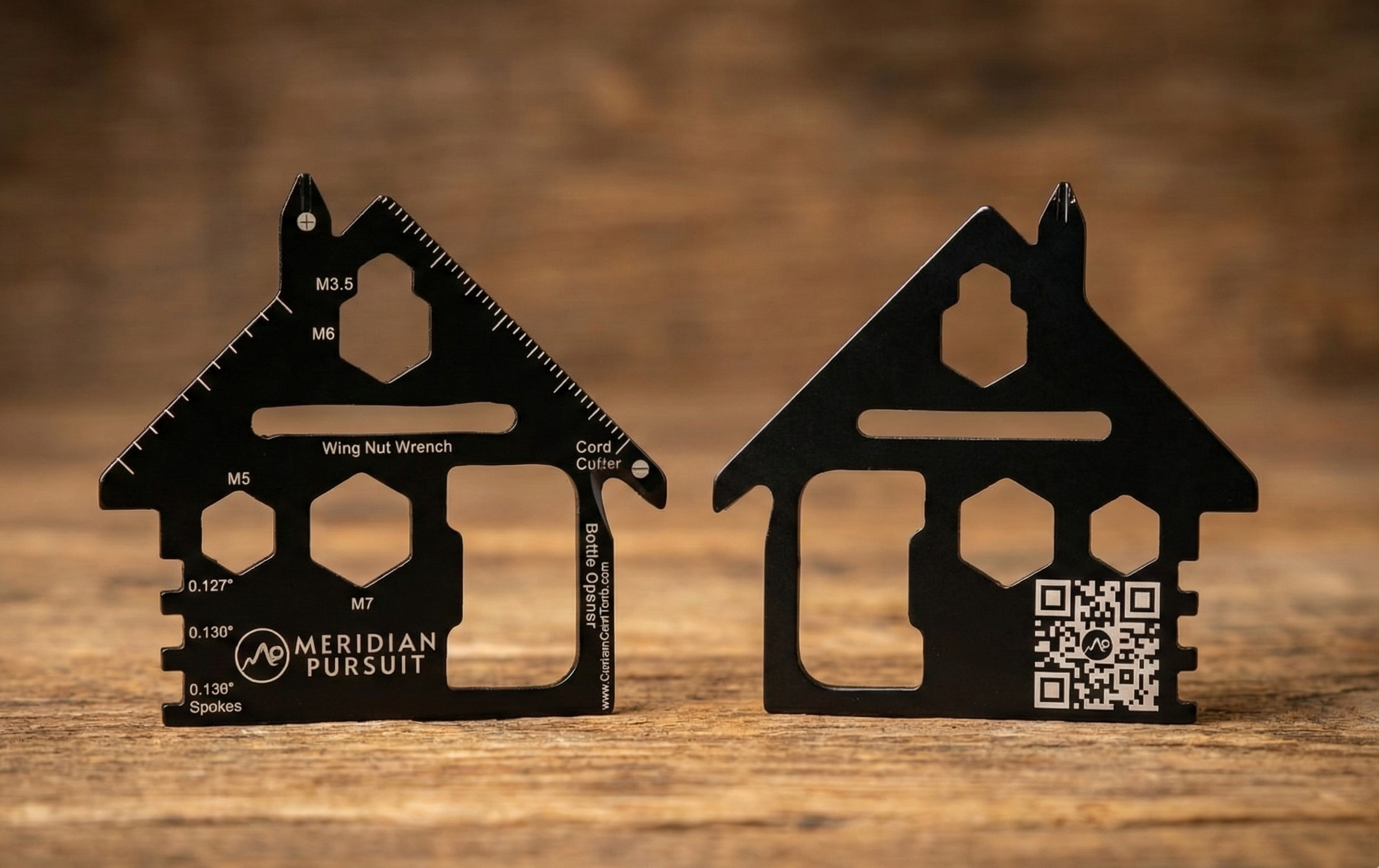 Two black house-shaped tools on a wooden surface with 'Meridian Pursuit' branding.