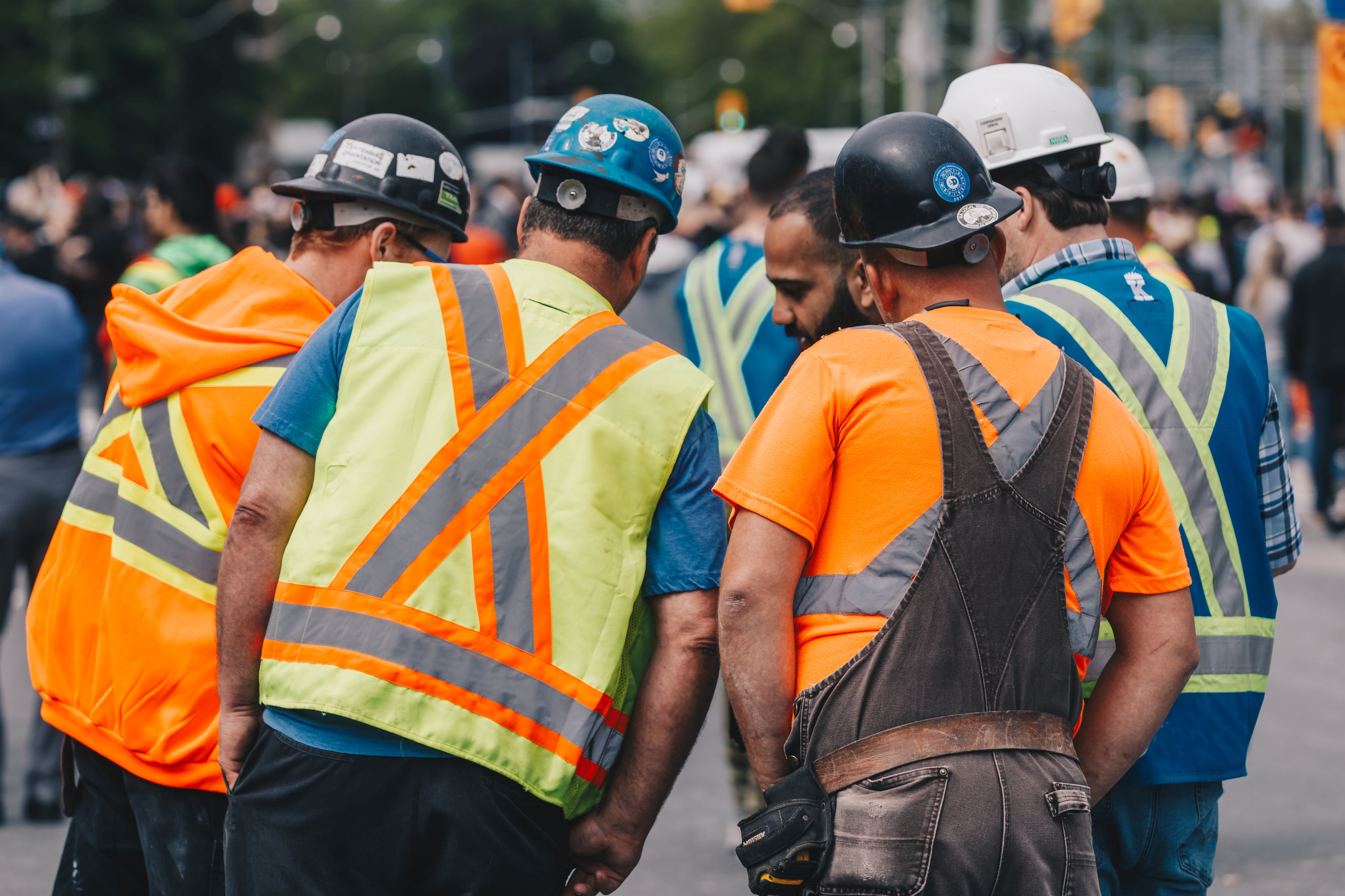 Construction workers standing in a group looking at something outside
